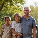 Hombre de mediana edad sonriendo con sus hijos